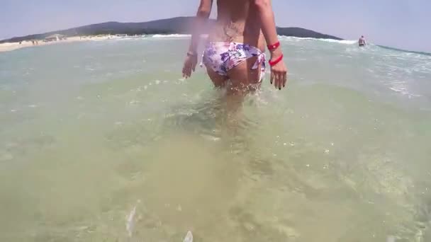 浅い水の中を歩く女の子ローアングルショットと波に飛び込む — ストック動画