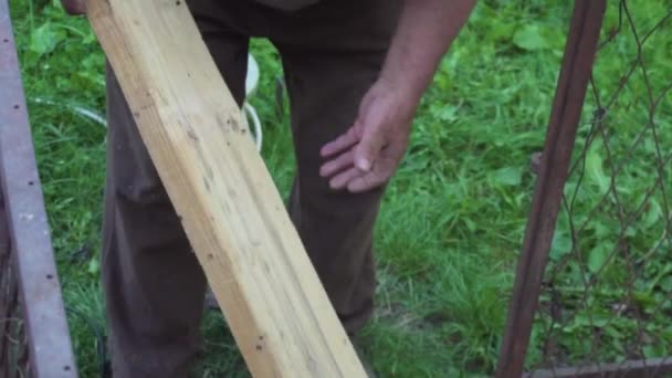 Alter Mann Misst Mit Meißel Eine Planke Und Sägt Sie — Stockvideo