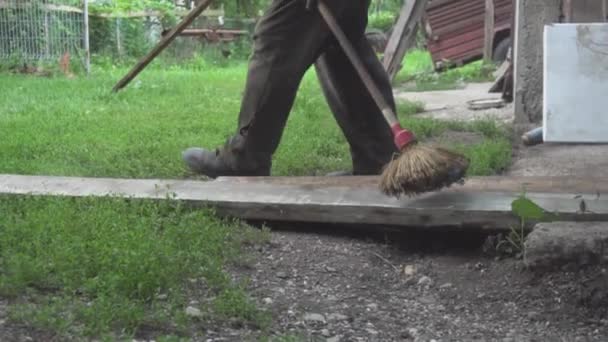 Человек Чистящий Деревянную Доску Метлой — стоковое видео