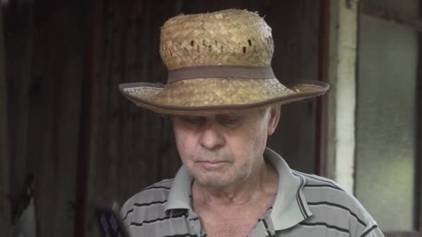 Old Man Wearing Straw Hat Answering Flip Phone — Stock Video