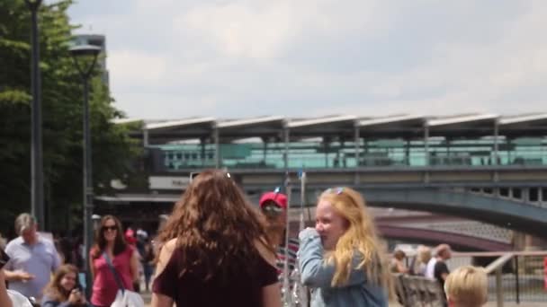 三人组年轻姑娘在伦敦堤岸观看街头表演者制造肥皂泡 — 图库视频影像