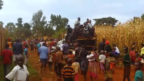 Duży Tłum Afrykanów Idących Brudną Drogą Świętujących Zwycięstwo Polityczne Ciężarówką — Wideo stockowe