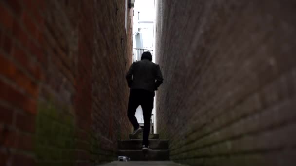 Hombre Caminando Por Callejón Ladrillo Oscuro — Vídeo de stock