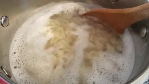 木製のスプーンで沸騰マカロニパスタを攪拌 — ストック動画