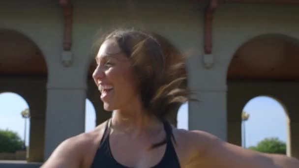 快乐的千年女性健身教练摆动着她的胳膊 热身起来 向上和向下倾斜的衣服 — 图库视频影像