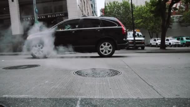市内の男の穴の排気ガスを通過する車 — ストック動画