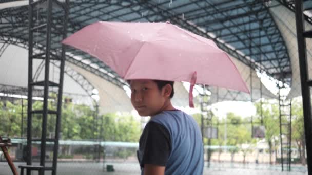 Zeitlupe Eines Vorpubertären Asiatischen Jungen Der Bei Regen Einen Rosa — Stockvideo