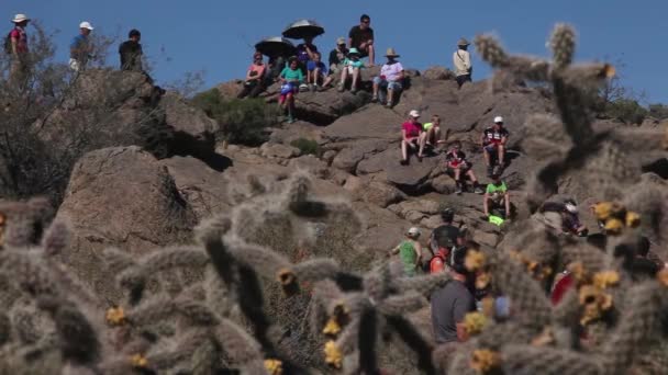 在亚利桑那州的沙漠中 观看山地骑车人骑在岩石障碍物下的旁观者 — 图库视频影像