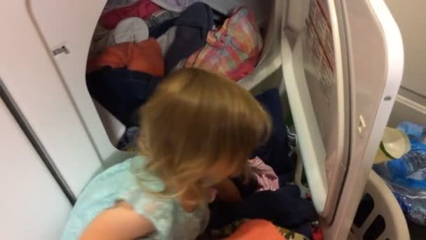 Kurutucudan Çamaşır Çıkaran Küçük Bir Kız Annesine Işlerinde Yardım Ediyor — Stok video