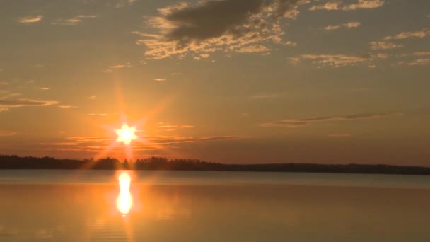湖の上に日の出のタイムラプス 太陽は湖に反射する 空に雲が — ストック動画