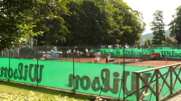 女子テニス選手は強くプレーする クレイ裁判所 暑い夏の日 — ストック動画
