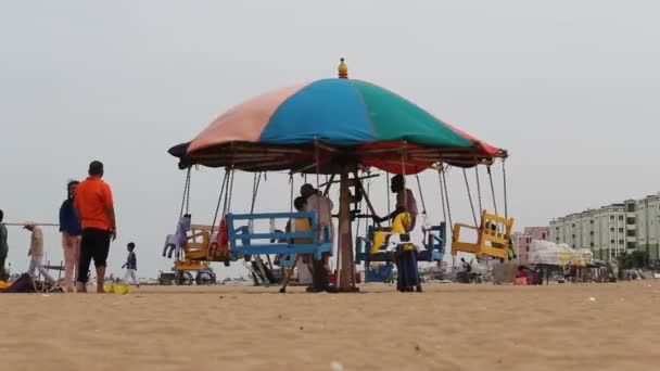 어른들 과어린 아이들은 마리나 해변에서 말이나 회전목마타기를 즐긴다 — 비디오