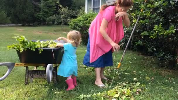 Matka a dceruška dělají zahradní práce, aby uklidili dům