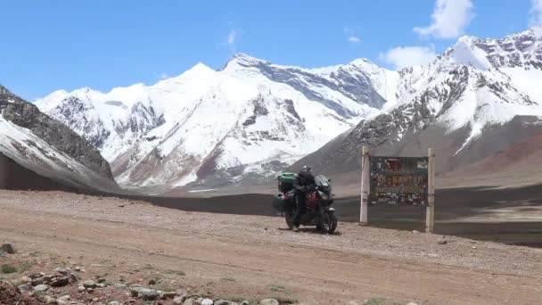 BIke Rider táhnoucí pryč ze zasněžených hor v Tádžikistánu.