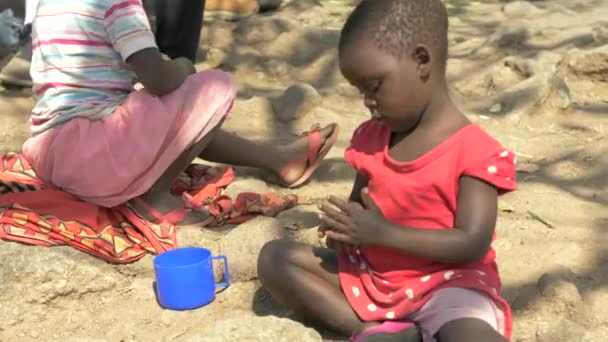 Ung Afrikansk Flicka Sitter Marken Och Leker Med Sten Med — Stockvideo