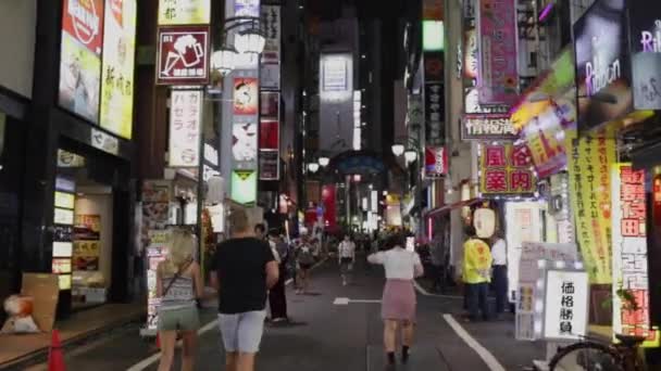 在日本东京新宿的Kabukicho区 与众多商铺一起沿街行走 — 图库视频影像