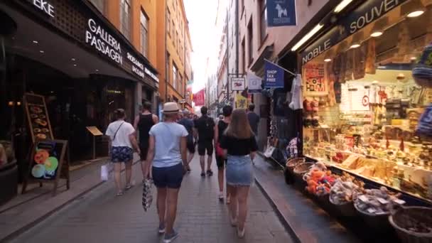 在瑞典斯德哥尔摩老城散步的人 平稳滑行摄像头镜头向前移动 很多人路过 Gamla Stan美丽的瑞典古老建筑 — 图库视频影像