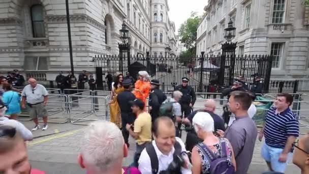 トランプ大統領の英国訪問に対する抗議の日に ダウニング街のバリアの外で警察官と議論する2人の移住者 — ストック動画