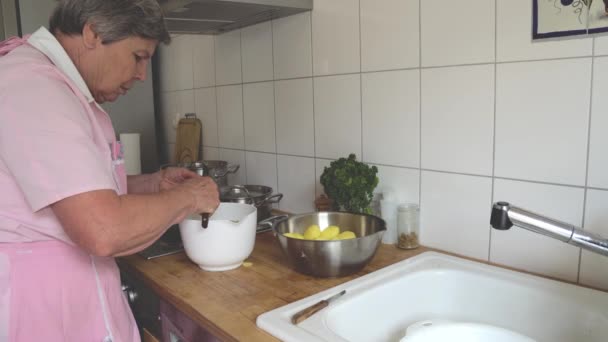 Seniorin Schält Hause Kartoffeln — Stockvideo
