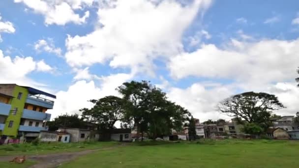 雲に覆われた青い空と緑の芝生とインドの家と木のハイパーラプスまたはタイムラプス 前方に移動するカメラ — ストック動画