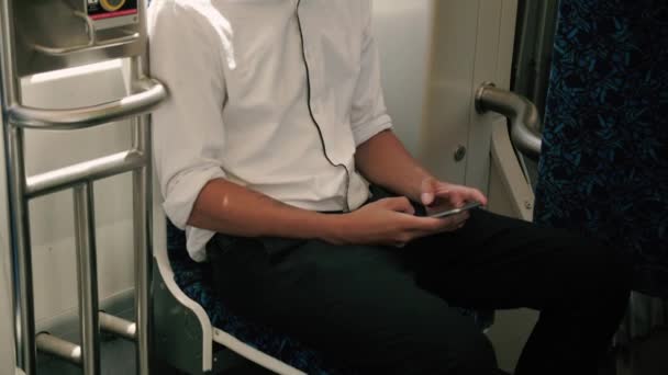 年轻英俊的专业人士独坐 在换乘公交时使用他的电话 双手合拢 面朝上倾斜 动作缓慢 — 图库视频影像