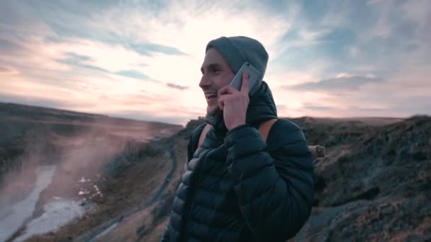 Feliz Joven Hablando Por Teléfono Celular Mientras Camina Cerca Cascada — Vídeo de stock