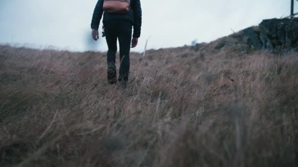 アイスランドの丘を歩いている若い男の超スローモーションショット — ストック動画