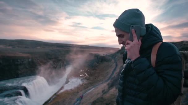 Joven Hablando Por Teléfono Celular Mientras Camina Cerca Cascada Gullfoss — Vídeo de stock