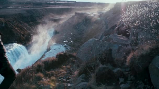 アイスランドのガルフロス滝を見下ろすトレイルでの若い男のハイキング — ストック動画