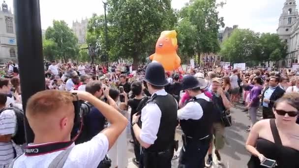 트럼프 대통령의 방문에 반대하는 운동가들은 주황색 풍선을 행진하고 — 비디오