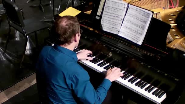 青いシャツを着た男が学校のコンサートでグランド スタインウェイ ピアノを演奏している — ストック動画