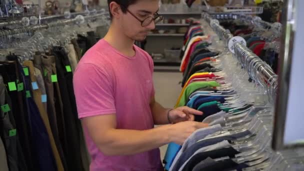 Adolescent Garçon Regarder Travers Rack Vêtements Dans Magasin — Video