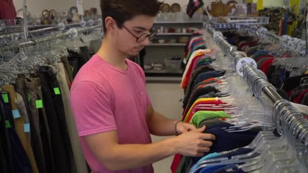 Adolescent Garçon Regarder Travers Rack Vêtements Dans Magasin — Video