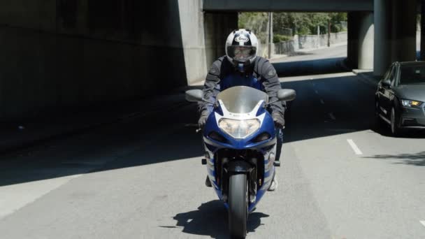 Slow Motion Mann Fährt Motorrad Unter Straßenbrücke Durch Schatten Beim — Stockvideo