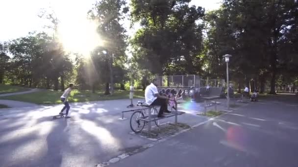 Hombre Caminando Parque Pasando Skateboarders — Vídeo de stock