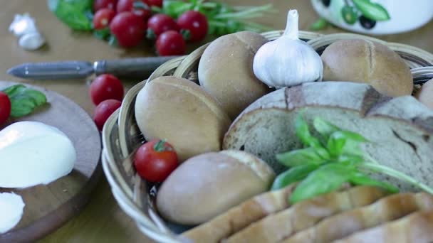 桌上放有面包和番茄酱的静态篮子 篮子周围放着莫扎拉 西红柿 大蒜和罗勒 — 图库视频影像