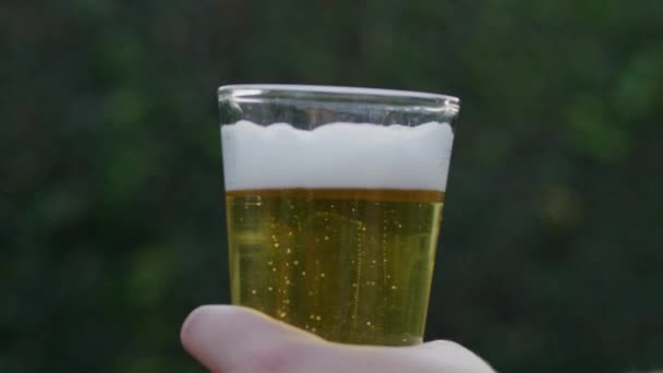Slow Motion Υψώνοντας Ένα Ποτήρι Μπύρα Στο Χέρι Θολή Φόντο — Αρχείο Βίντεο