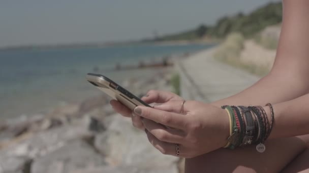 Młoda Atrakcyjna Kobieta Siedzi Plaży Wykorzystuje Swój Smartfon Dokonywania Zakupów — Wideo stockowe