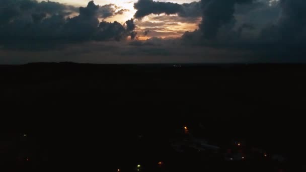 Drone Przechodzi Przez Wiejskie Miasto Burzami Horyzoncie Podczas Zachodu Słońca — Wideo stockowe