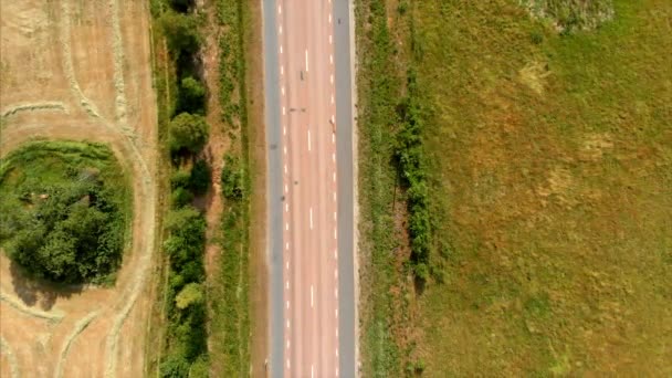 車が通過する道路の方へ降下するドローン映像 — ストック動画