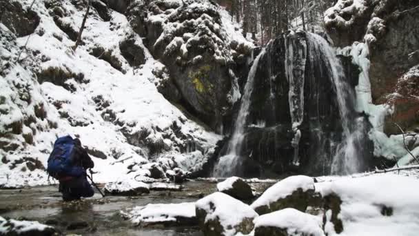 Fotógrafo Frente Una Cascada Congelada Está Tomando Fotos Rodillas Arroyo — Vídeo de stock