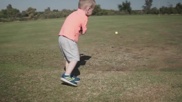 一个小男孩朝洞口打高尔夫球 朝洞口走去 — 图库视频影像
