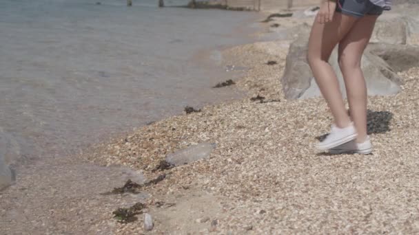 年轻女子沿着海滩散步 慢动作捡起塑料瓶 未分级 — 图库视频影像