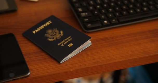 在木制电脑桌上手持式推入推出一本美国护照 — 图库视频影像
