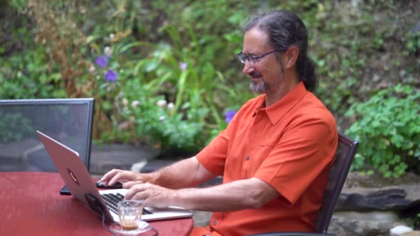 Sentado Café Jardín Aire Libre Hombre Con Camisa Naranja Sonríe — Vídeos de Stock