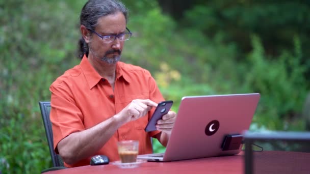 Felnőtt Férfi Szabadtéri Asztalnál Számítógép Kávé Dolgozik Egy Okostelefon — Stock videók