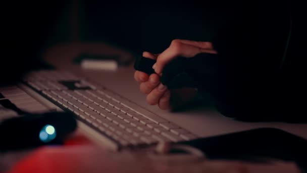 ハッカーの手は ゆっくりとポイントAからポイントB 背景のキーボードにそれを移動し メモリカードを保持する 赤い光の闇の中で — ストック動画