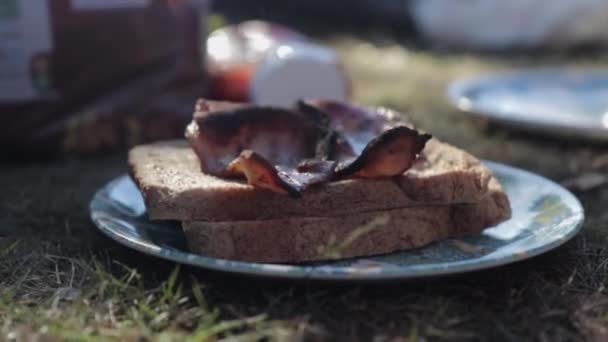 キャンプ休暇中に調理ベーコンサンドイッチの上昇ショット 時間帯 — ストック動画