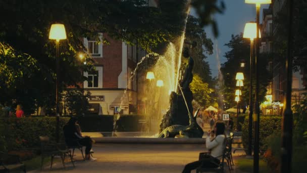 人们在斯德哥尔摩的一个晚上有喷泉的公园里 — 图库视频影像