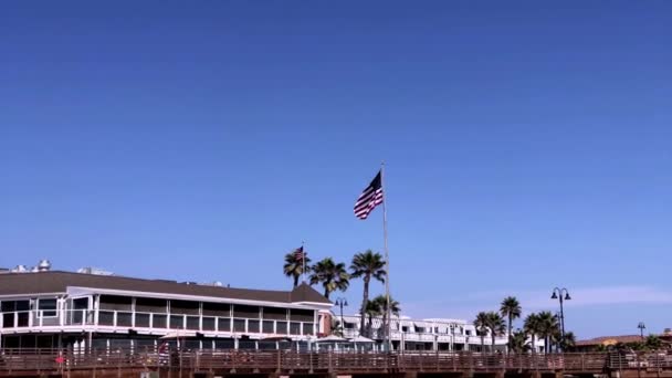 Amerikansk Flagga Viftar Pismo Beach Över Ett Hotell Med Klarblå — Stockvideo